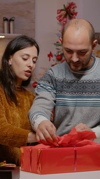 Couple preparing gift box for family on christmas eve festivity