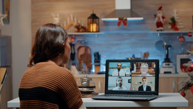 Woman on video call with workmates at home