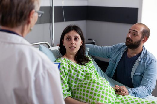 Obstetrics doctor talking to couple with pregnancy