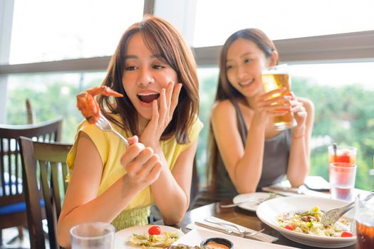 Happy  young woman enjoying food and drink in restaurant