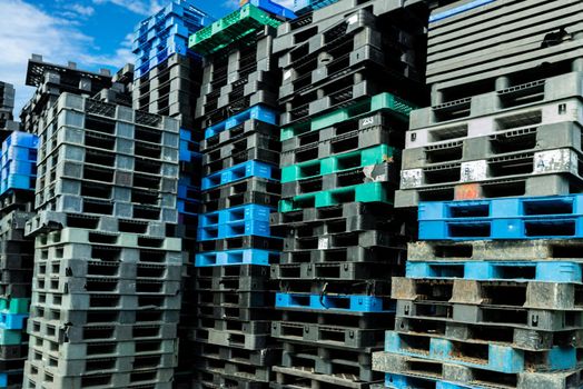 Pile of plastic shipping pallet. Industrial plastic pallet stacked at factory warehouse. Cargo and shipping concept. Plastic pallet rack for export delivery industry. Plastic pallet storage warehouse.