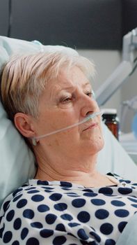 Portrait of retired woman with sickness laying in bed