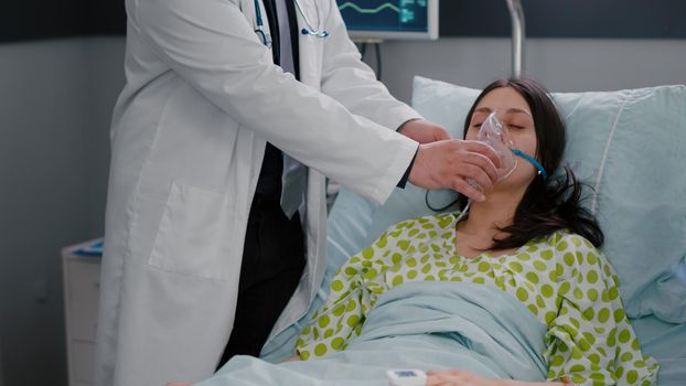 Clinical team monitoring patient putting oxigen mask analyzing respiratory condition