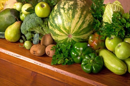 Useful green vegetables on a wooden background.