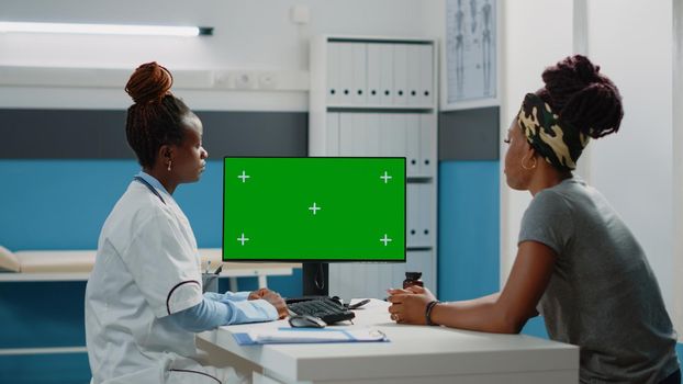 Medical specialist looking at horizontal green screen