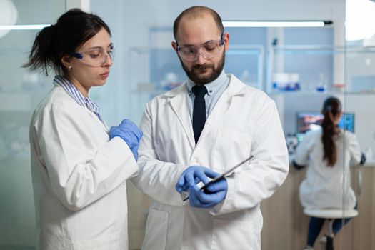 Scientist woman analyzing virus expertise with biologist researcher