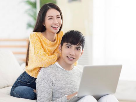 Young couple with laptop in the living room.