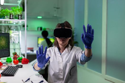 Biologist researcher woman wearing virtual reality headphones