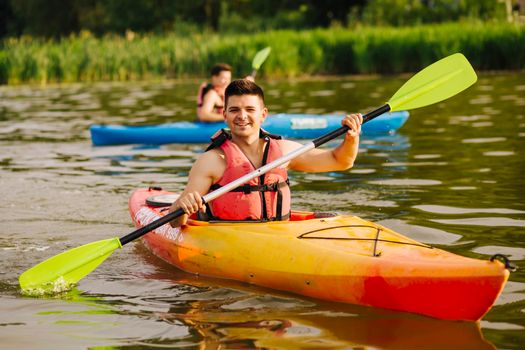 smiling man paddling kayak lake. High quality photo