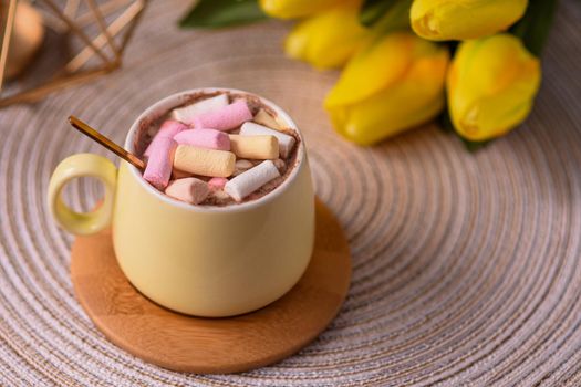 Marshmallows in a coffee cup with a golden teaspoon 