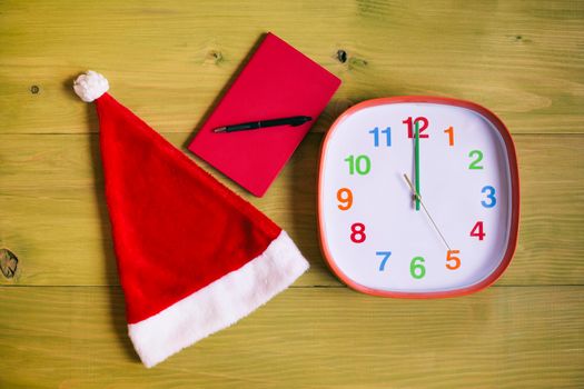 Santa Hat,personal organizer and clock showing midnight wooden table