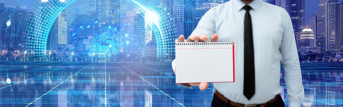 Picture Of Businessman Holding Empty Page Graphing Notebook Around Futuristic Technology. Employee Presenting Blank Workbook Surrounded By Modern Automation.