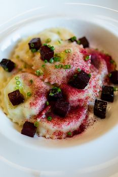 Cooking classes. Modern style dish presentation. Ravioli and beetroot, scallions 