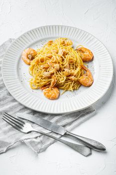 Rose pesto prawn pasta, on plate, on white stone surface