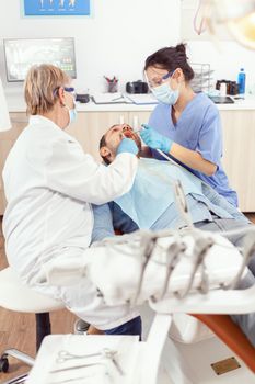 Stomatologist senior woman performing examination and taking care of teeth