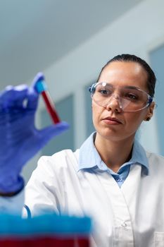 Scientist doctor holding blood vacutainer analyzing during biochemistry experiment