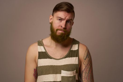 national bearded man in a striped jersey hipster tattoos on his arms. High quality photo