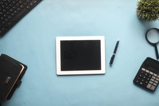 Flat composition of digital tablet and office stationary on black background