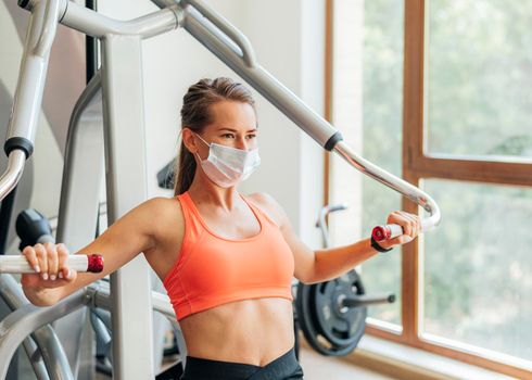woman gym doing exercises with medical mask. High quality photo