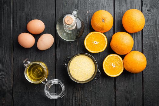 Orange polenta cake ingredients, with eggs and honey, on black wooden table background, top view flat lay
