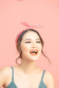 Portrait of beautiful young woman with bun hair on pink background