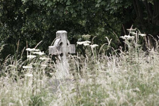Graveyard with cross shaped headstone isolation loneliness