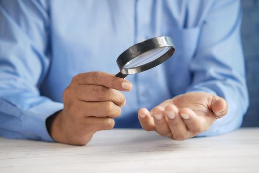 young men discovering his luck with magnifying glass