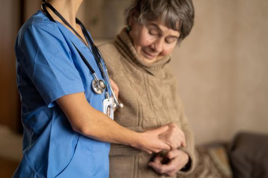 A young nurse shows care and professionalism in relation to an elderly woman.