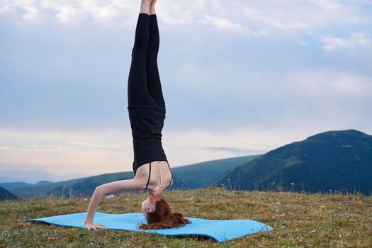 sportive woman workout meditation in the mountains outdoors