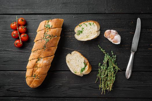 Toasted bread with garlic and herbs, on black wooden table background, top view flat lay