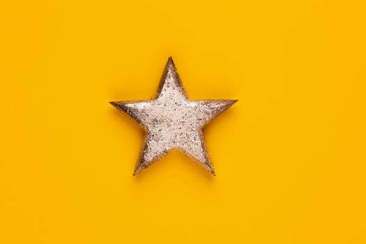 Christmas star decor on yellow colored background. 