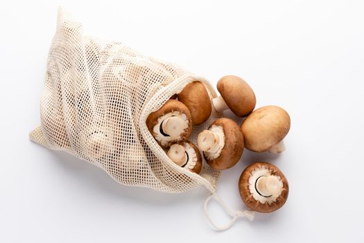 Fresh Champignon mushrooms eco cotton bags on white background. 