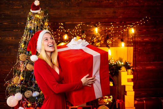 Woman with Christmas mood. Young woman in elegant red dress over Christmas interior background. Luxury Christmas woman. Christmas and new year holidays.
