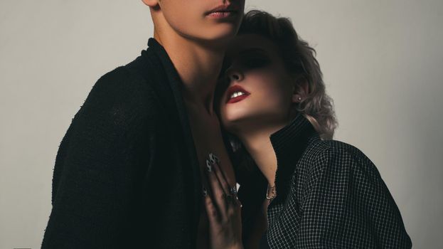 Affectionate couple having a fun while a photo session. Young heterosexual couple embracing. Close up photo. Portrait of happy loving couple. Handsome guy is hugging pretty girl with short hair.