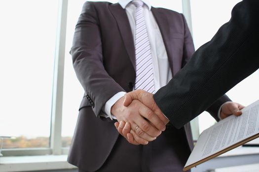 Man in suit shake hand as hello in office