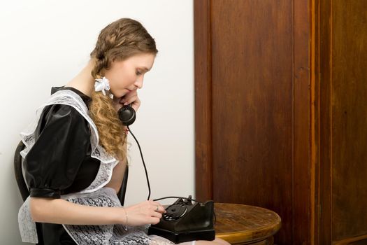 Emotional pretty school girl talk by vintage phone
