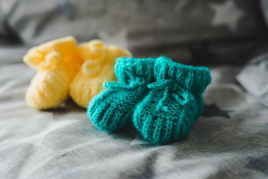 Mint and yellow knitted booties for a child.