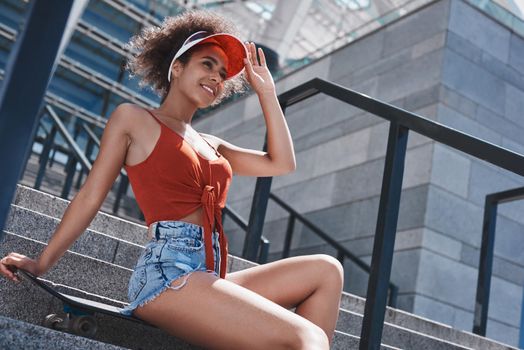 Young woman in visor free style on the street sitting on stairs