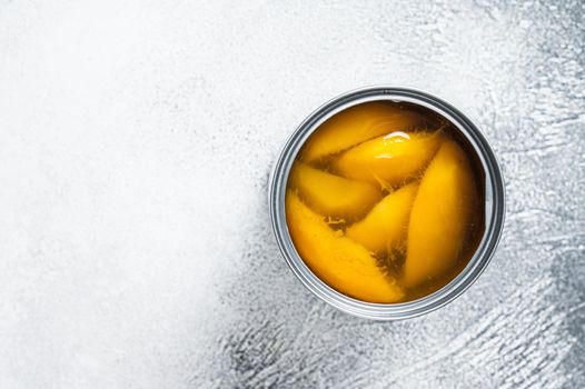 Canned mango slices in syrup in a metal can. White background. Top view. Copy space