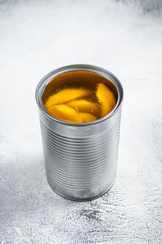Canned mango slices in syrup in a metal can. White background. Top view