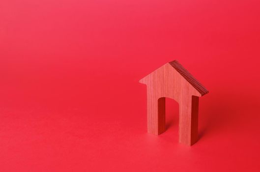 Red arch house figurine. Affordable housing. Rent of real estate. Repair and renovation, modernization. Minimalism. Red login background. Concept entrance. Realtor services.