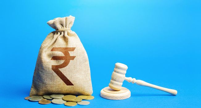 Indian rupee money bag and judge's gavel. Litigation, dispute resolution, conflict of interest settlement. Justice. Lawyer services. Awarding moral financial compensation. Protection rights.