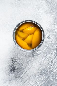 Canned mango slices in syrup in a metal can. White background. Top view