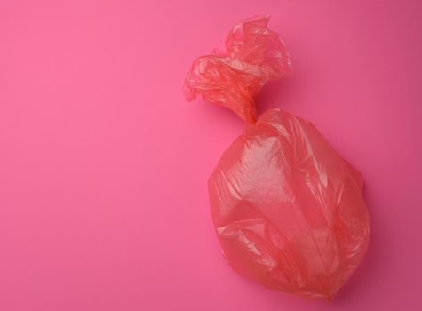 empty plastic trash bag on pink background