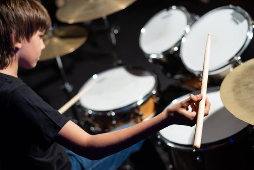 A boy plays drums in a recording studio