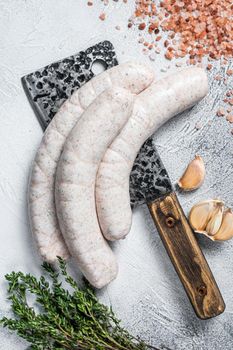 Bavarian traditional white sausages on a meat cleaver. White background. Top view