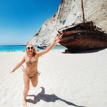 Woman relaxing on the famous Shipwreck Navagio beach in Zakynthos Greece.