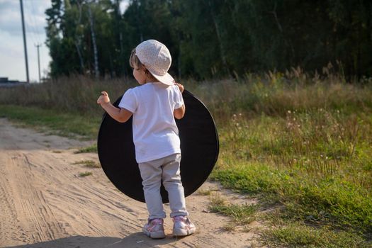 a toddler holds a reflector for the photographer. little helper assistant