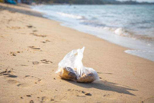 plastic bag lying on a sandy tropical beach. environmental pollution