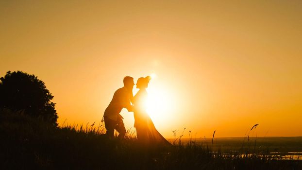 Romantic Silhouette of Man on high hill - at Sunset - kissing and dancing slow motion
